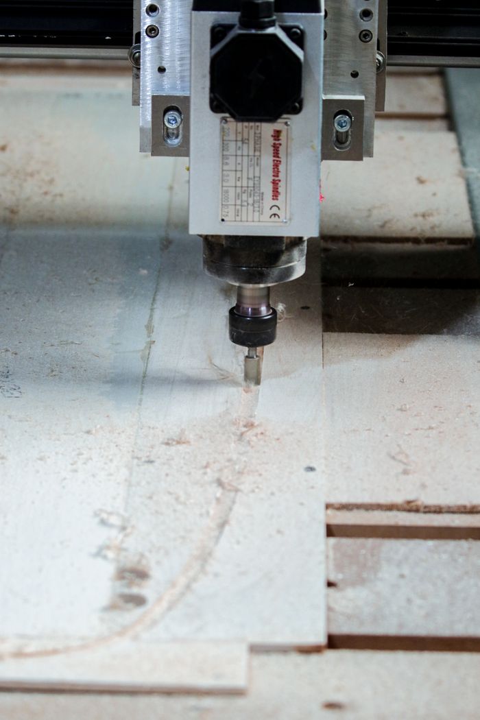 services-03 Close-up of a CNC milling machine precisely cutting wood in a carpentry workshop.